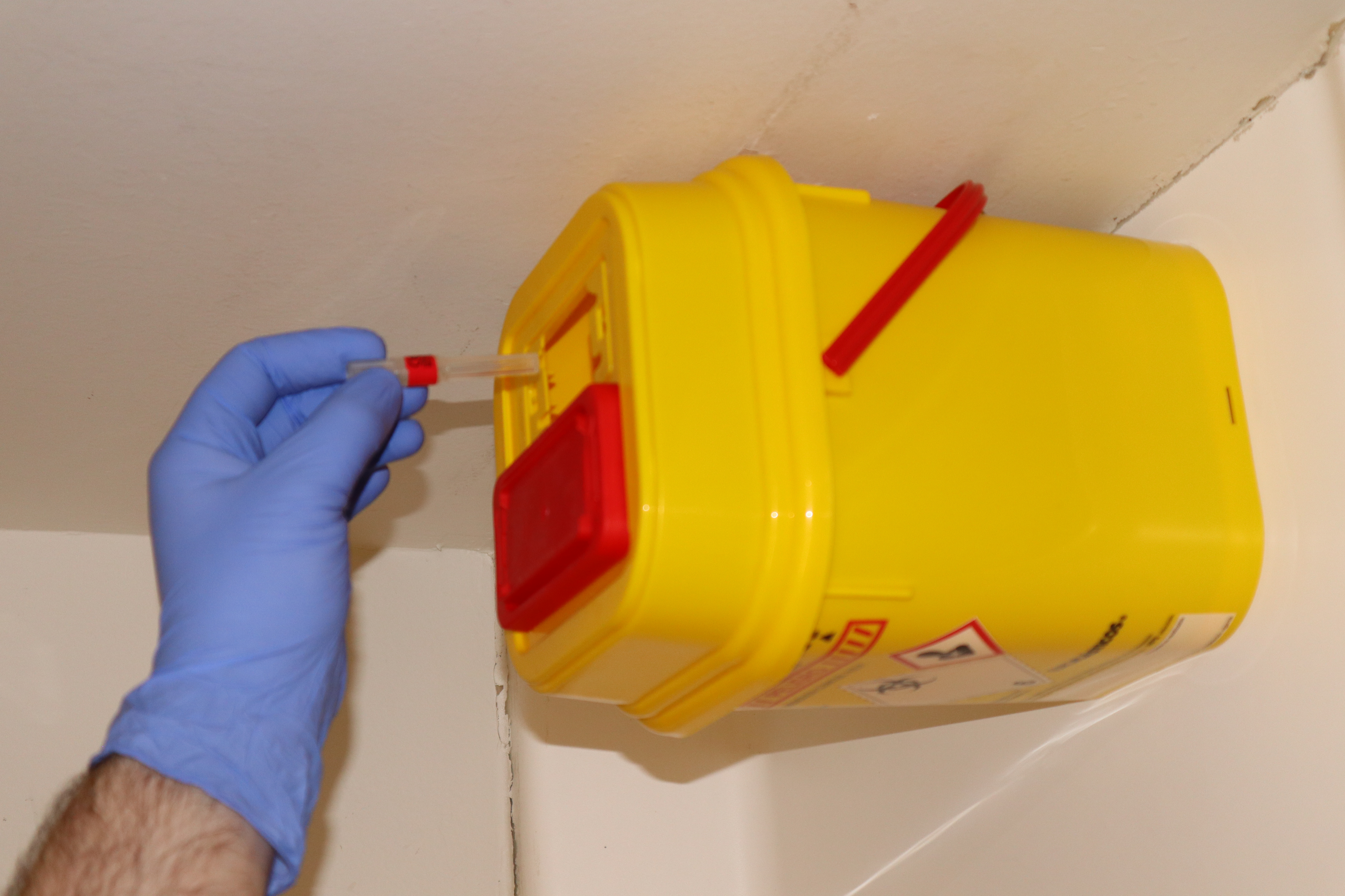 Yellow rigid container for sharps disposal.